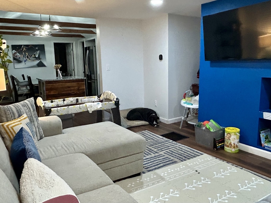 9 Church Street, Unit 9 Woburn, MA 01801 - Photo 2 of 31 a living room with furniture and a flat screen tv