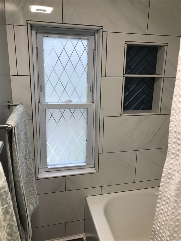 9 Church Street, Unit 9 Woburn, MA 01801 - Photo 21 of 31 a bathroom with a bathtub and window