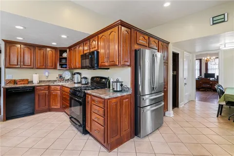 a kitchen with stainless steel appliances granite countertop a refrigerator a stove and a sink