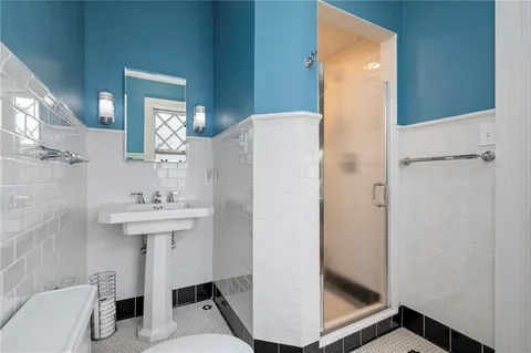 a bathroom with a sink a toilet and shower