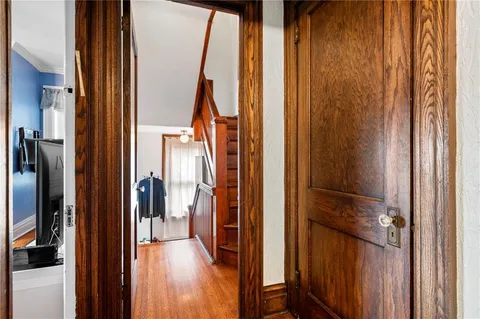 a view of a hallway with wooden floor and staircase