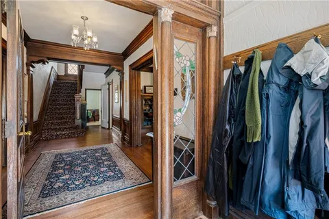 a view of a hallway with wooden floor and stairs