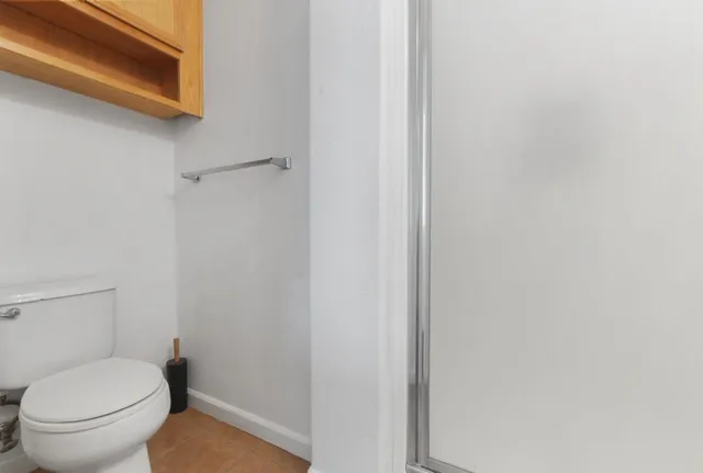 a white toilet sitting next to a shower