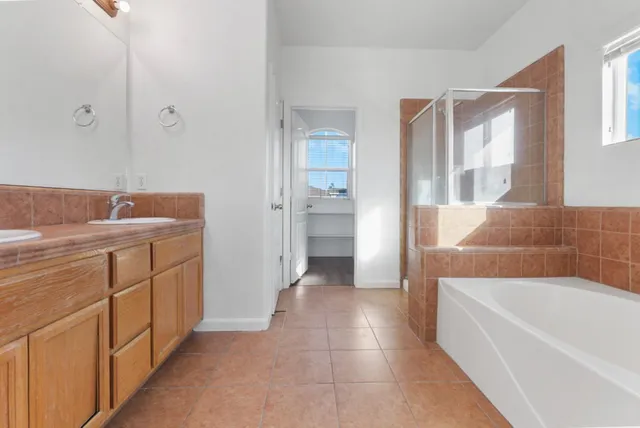 a bathroom with a tub sink and mirror