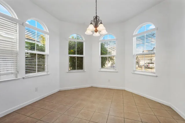 an empty room with windows and chandelier