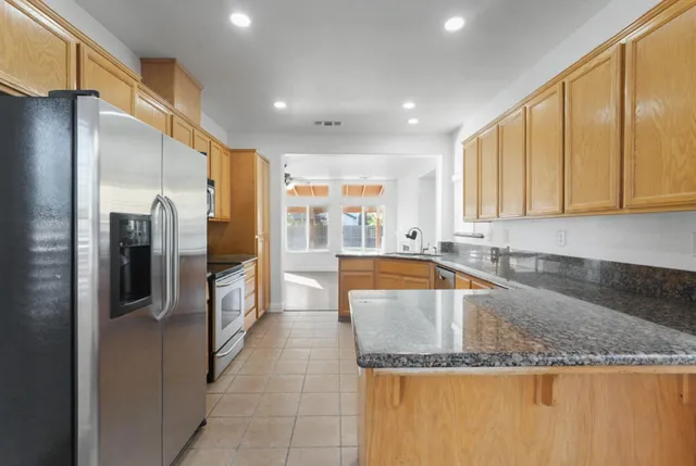 a kitchen with stainless steel appliances granite countertop a refrigerator and a sink