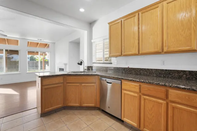 a kitchen with granite countertop sink cabinets and window
