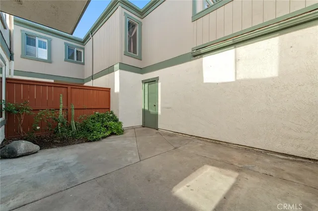 a backyard of a house with lawn chairs and iron fence