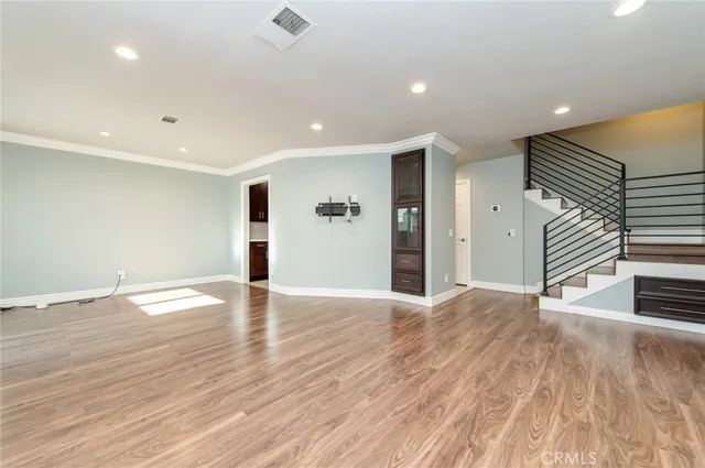 a view of an empty room with wooden floor