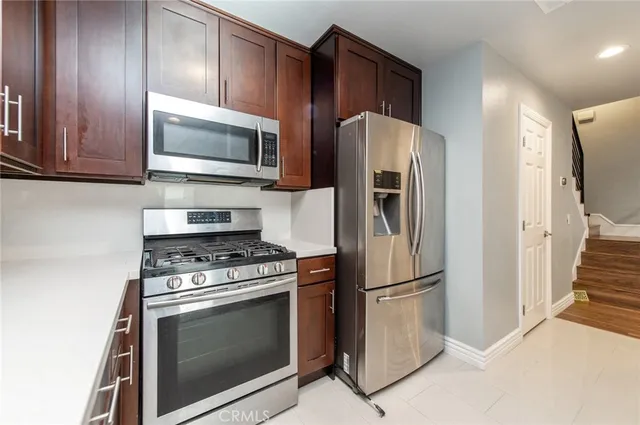 a kitchen with stainless steel appliances granite countertop a stove microwave and refrigerator