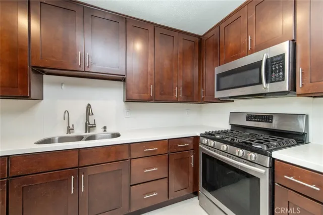 a kitchen with granite countertop cabinets stainless steel appliances and wooden cabinets