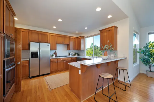 a kitchen with stainless steel appliances granite countertop a sink refrigerator and cabinets