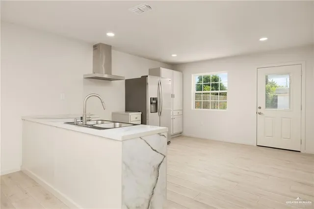 a kitchen with stainless steel appliances a sink stove and cabinets