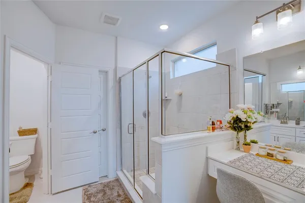 a bathroom with a granite countertop sink a toilet and shower