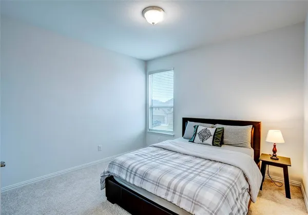 a bedroom with a bed and a lamp