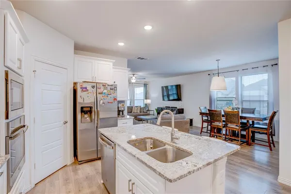 a kitchen with stainless steel appliances granite countertop a sink and a refrigerator