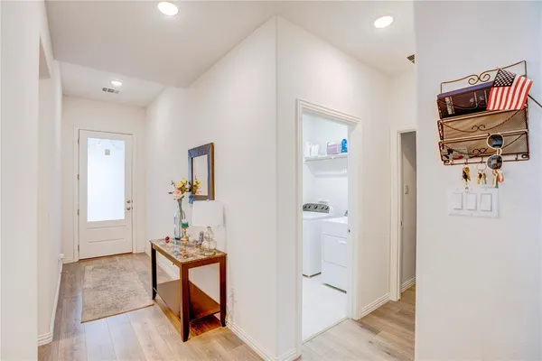 a view of a hallway to a livingroom with furniture and a window