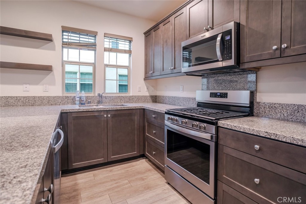 863 Iris Way, Unit B Azusa, CA 91702 - Photo 12 of 29 a kitchen with granite countertop cabinets stainless steel appliances and a window
