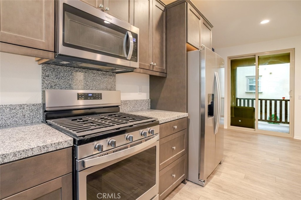 863 Iris Way, Unit B Azusa, CA 91702 - Photo 13 of 29 a kitchen with stainless steel appliances granite countertop a stove microwave and sink