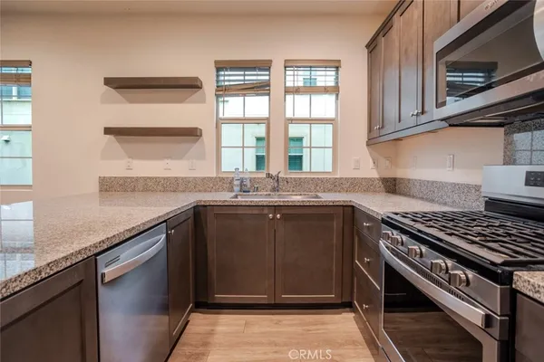 a kitchen with granite countertop a sink stove and cabinets