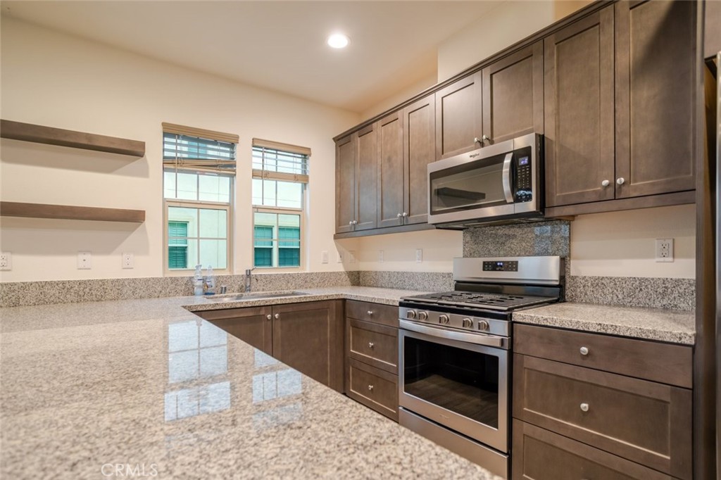 863 Iris Way, Unit B Azusa, CA 91702 - Photo 15 of 29 a kitchen with granite countertop a sink cabinets stainless steel appliances and a window