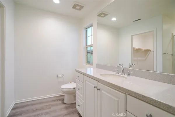 a bathroom with a granite countertop sink a toilet and a mirror
