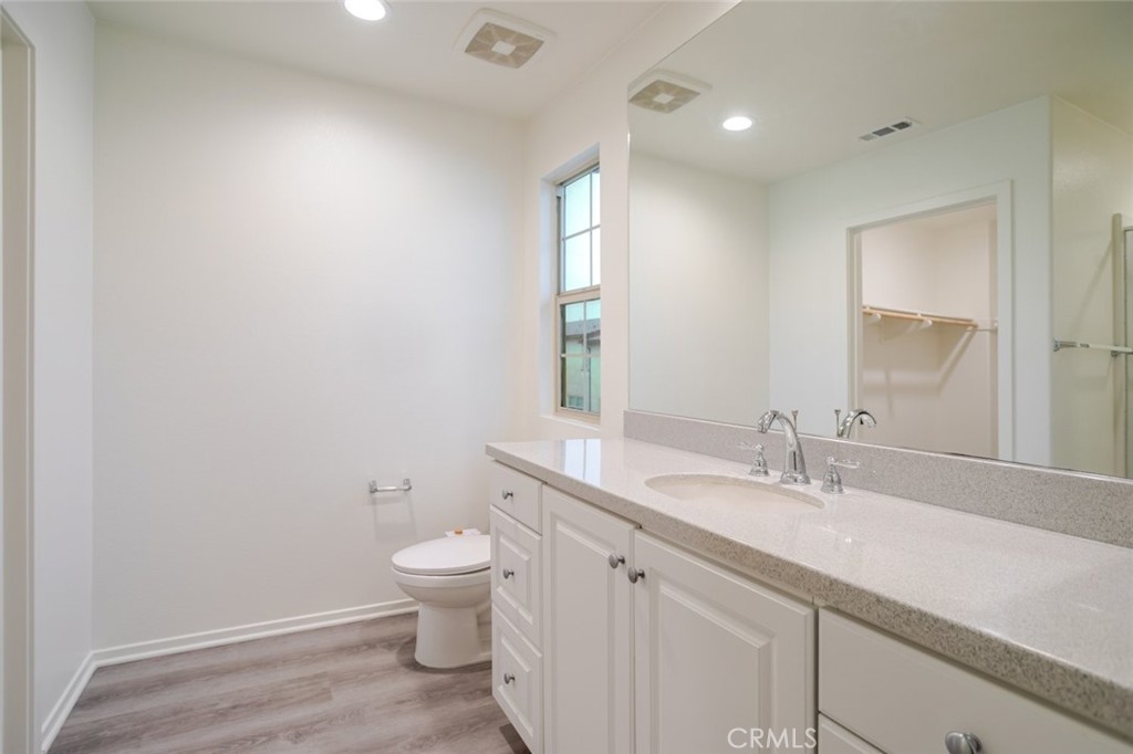 863 Iris Way, Unit B Azusa, CA 91702 - Photo 23 of 29 a bathroom with a granite countertop sink a toilet and a mirror