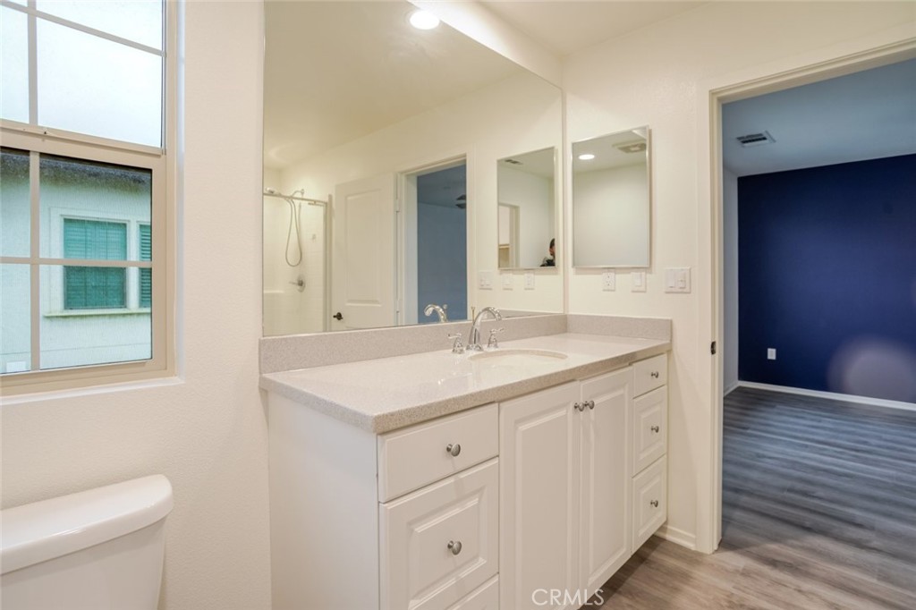 863 Iris Way, Unit B Azusa, CA 91702 - Photo 25 of 29 a bathroom with a granite countertop sink a toilet and a mirror
