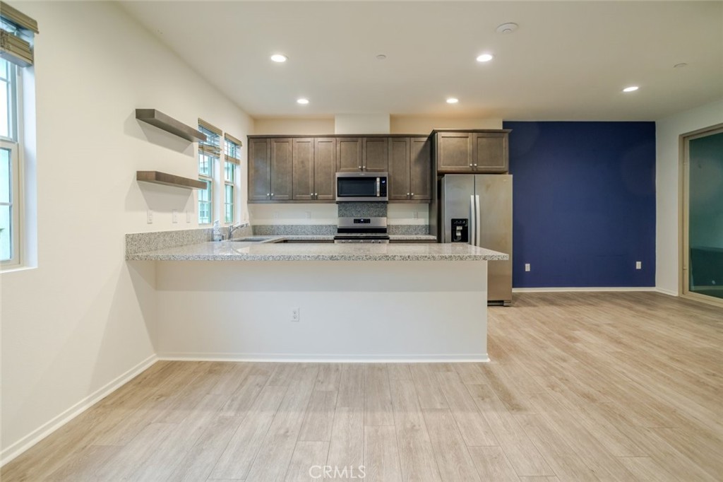 863 Iris Way, Unit B Azusa, CA 91702 - Photo 9 of 29 a view of kitchen with kitchen island a sink wooden floor and a refrigerator