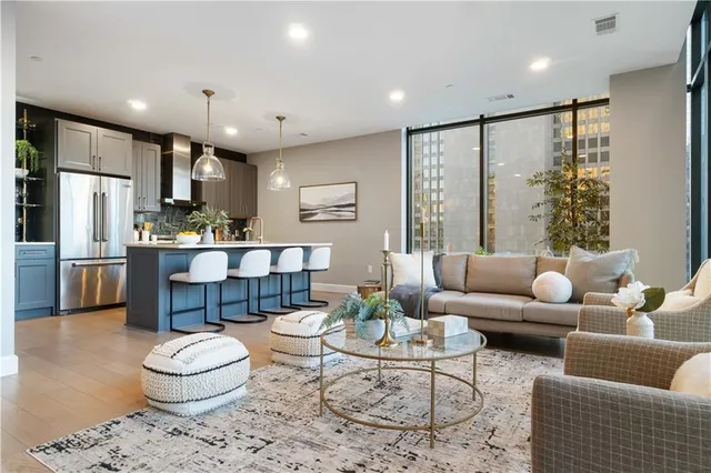 a living room with stainless steel appliances kitchen island granite countertop a couch and a view of kitchen