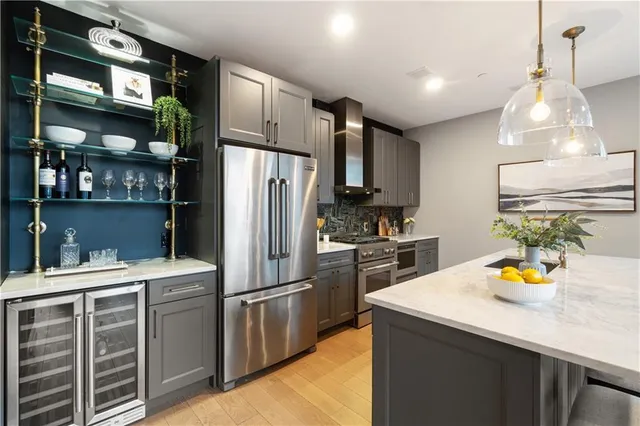a kitchen with stainless steel appliances granite countertop a stove a refrigerator and a sink