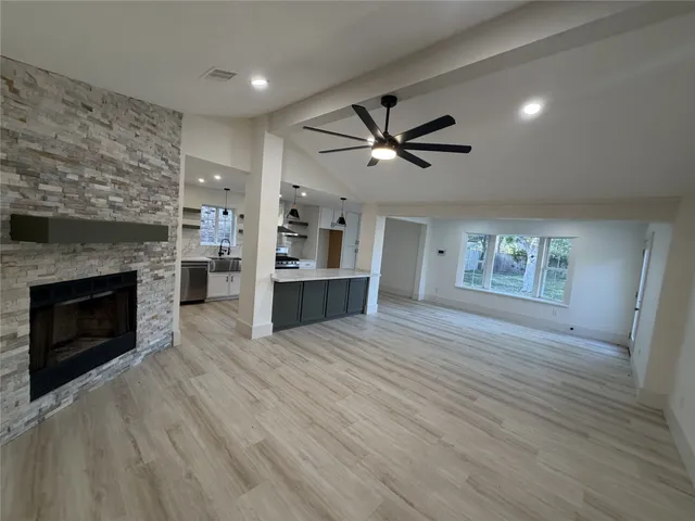 an empty room with windows and a fireplace