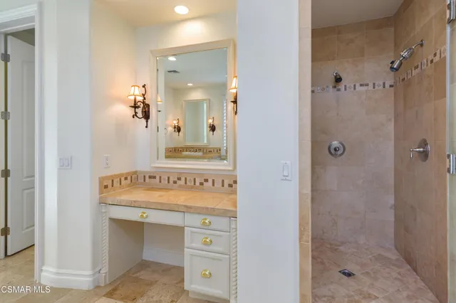 a bathroom with a sink mirror and shower