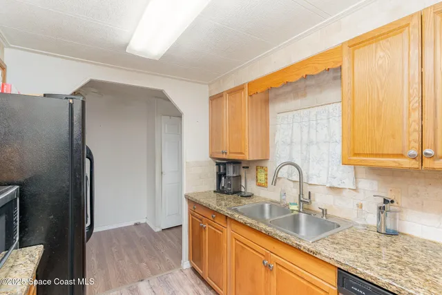 a kitchen with stainless steel appliances granite countertop a sink and a refrigerator