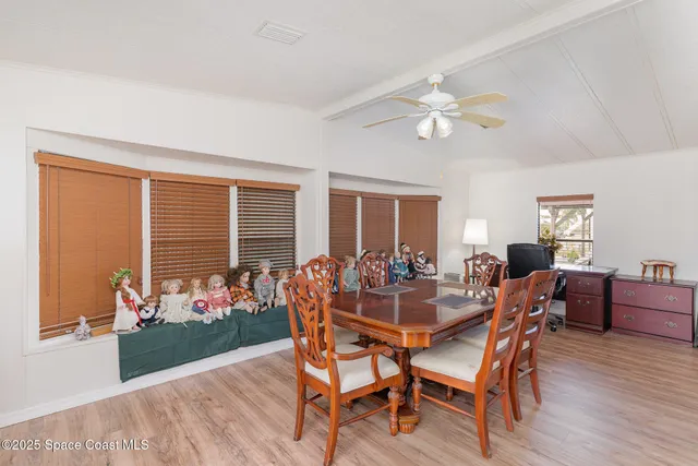 a dining room with furniture a flat screen tv and a window