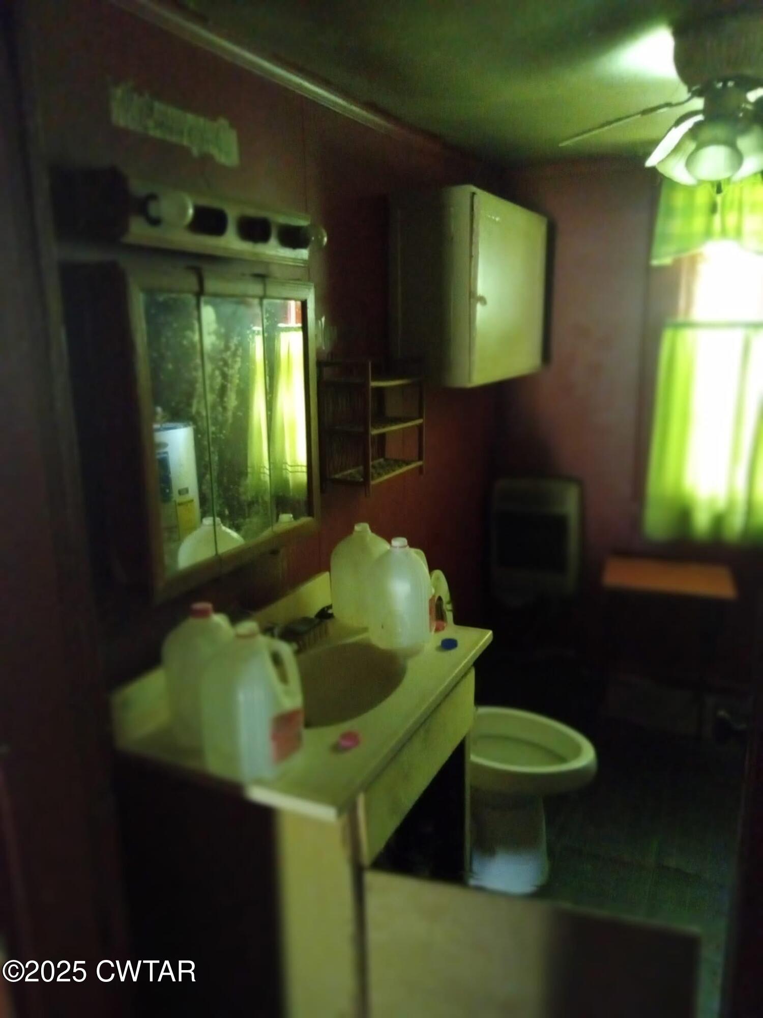 231 Jackson Street Jackson, TN 38301 - Photo 6 of 8 a bathroom with a toilet sink and mirror