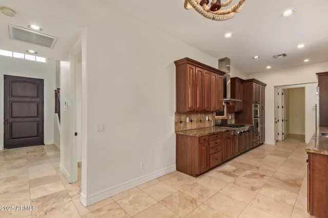 a kitchen with stainless steel appliances kitchen island granite countertop a refrigerator and a sink