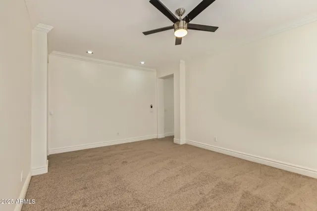 an empty room with closet and fan