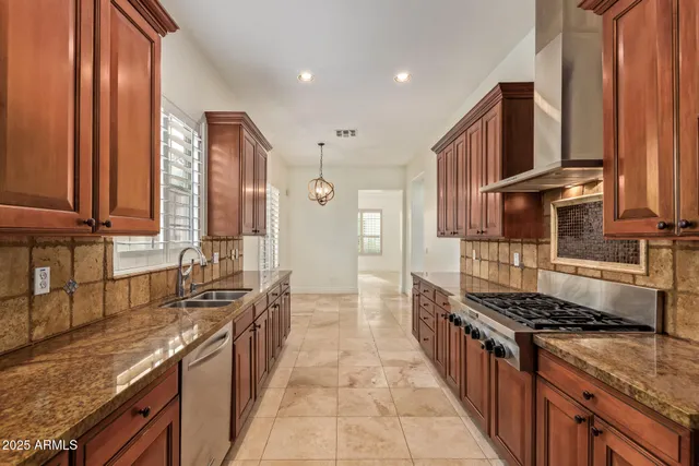 a kitchen with stainless steel appliances granite countertop a stove a sink and a refrigerator