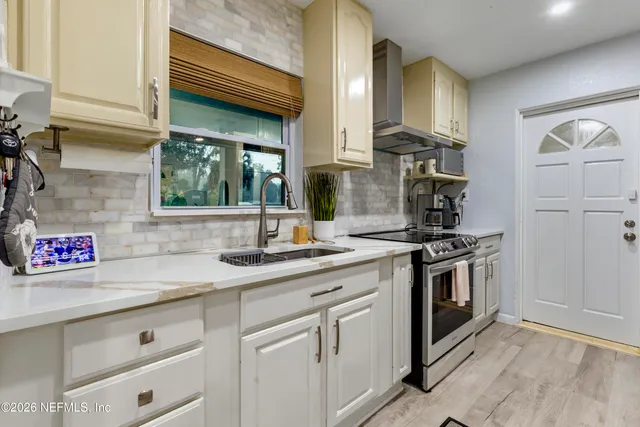 a kitchen with stainless steel appliances granite countertop a sink and a stove