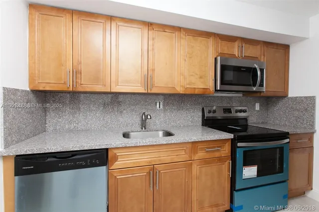 a kitchen with stainless steel appliances granite countertop a sink stove and microwave