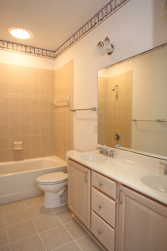 11612 Midlavian Drive Raleigh, NC 27614 - Photo 16 of 25 The large hall bath for the 2 other first floor bedrooms has a long counter with double sinks, tile flooring and tub surround. Downstarirs hall bath