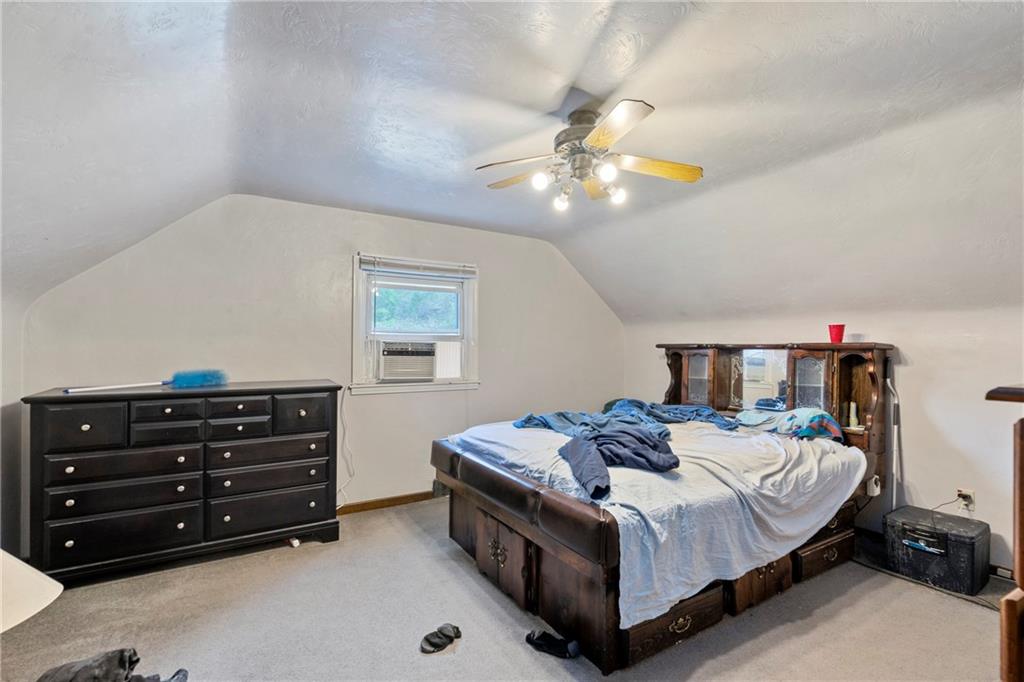 53 Lawrence Street Pittsburgh, PA 15209 - Photo 22 of 36 a bedroom with a bed and a chandelier