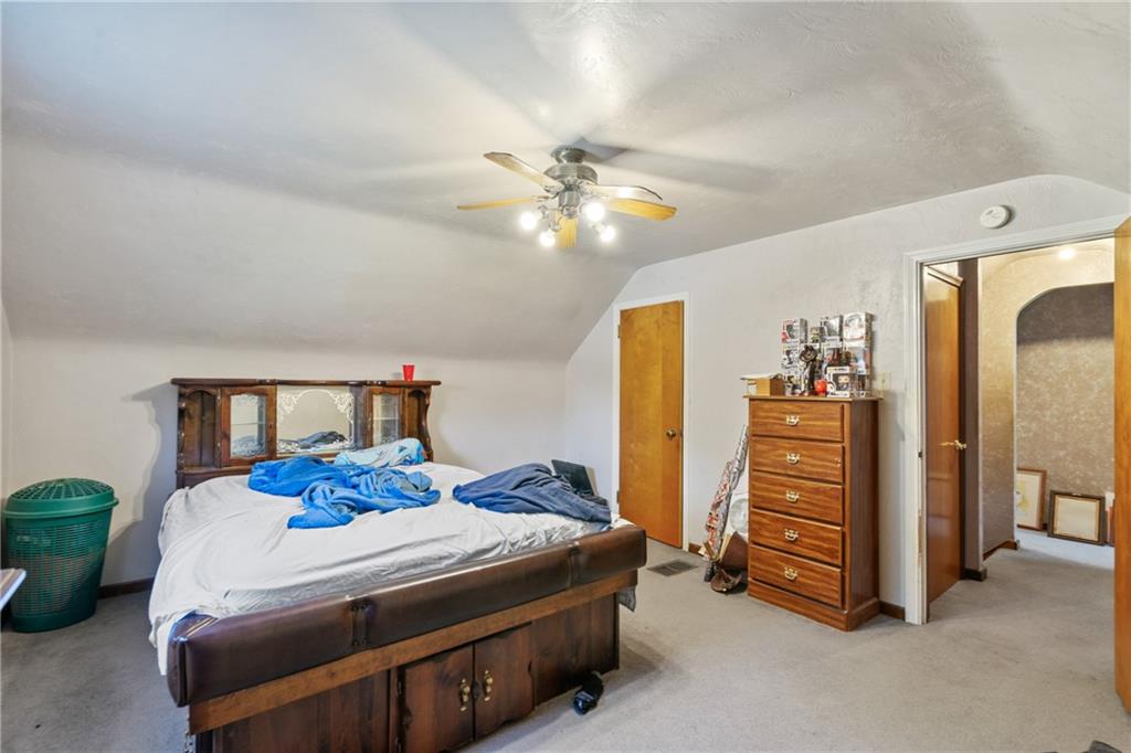 53 Lawrence Street Pittsburgh, PA 15209 - Photo 23 of 36 a bedroom with a bed and a chandelier