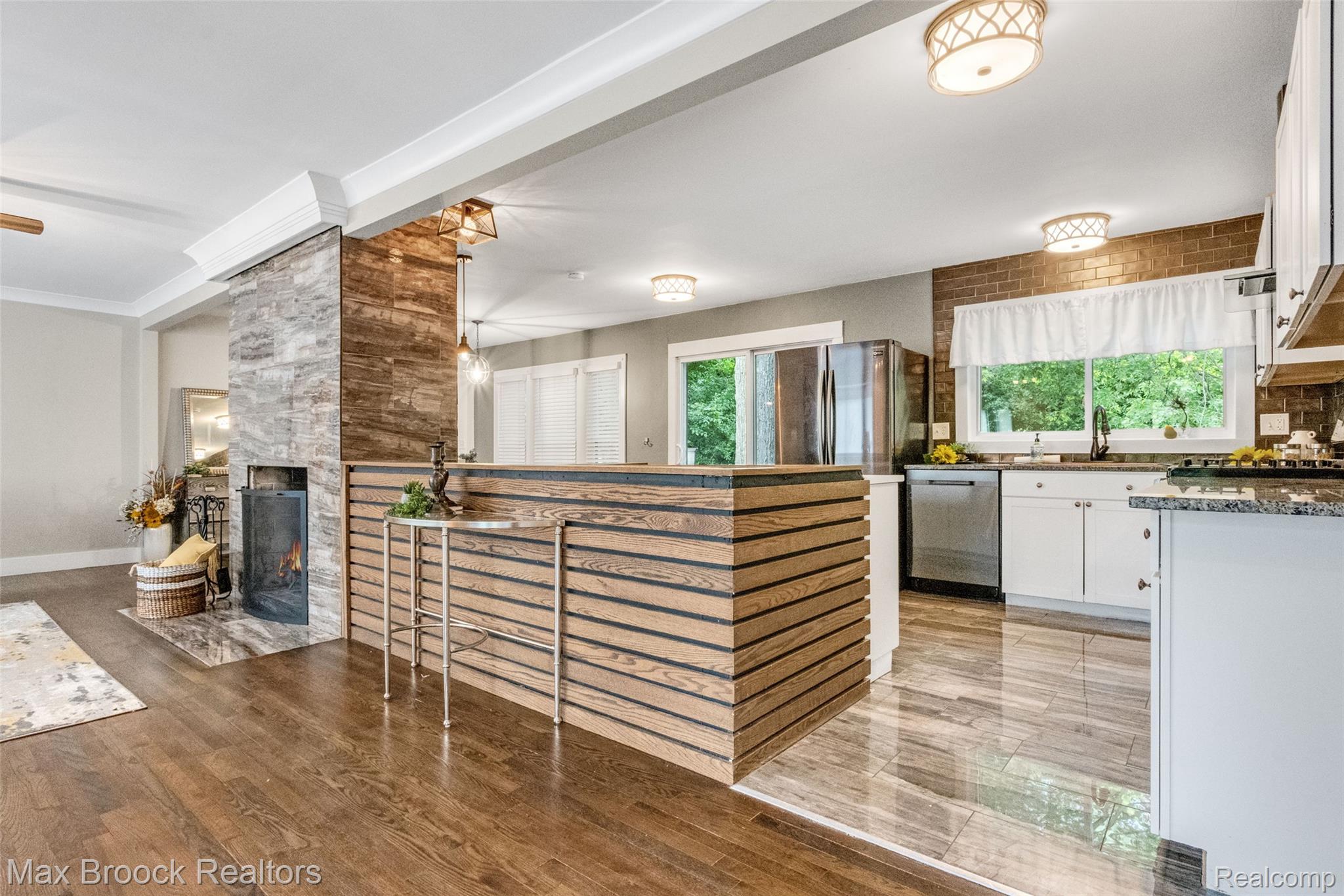 2905 Lahser Road Bloomfield Hills, MI 48304 - Photo 5 of 28 Open-concept living area with a stone-clad fireplace and wood-finish flooring