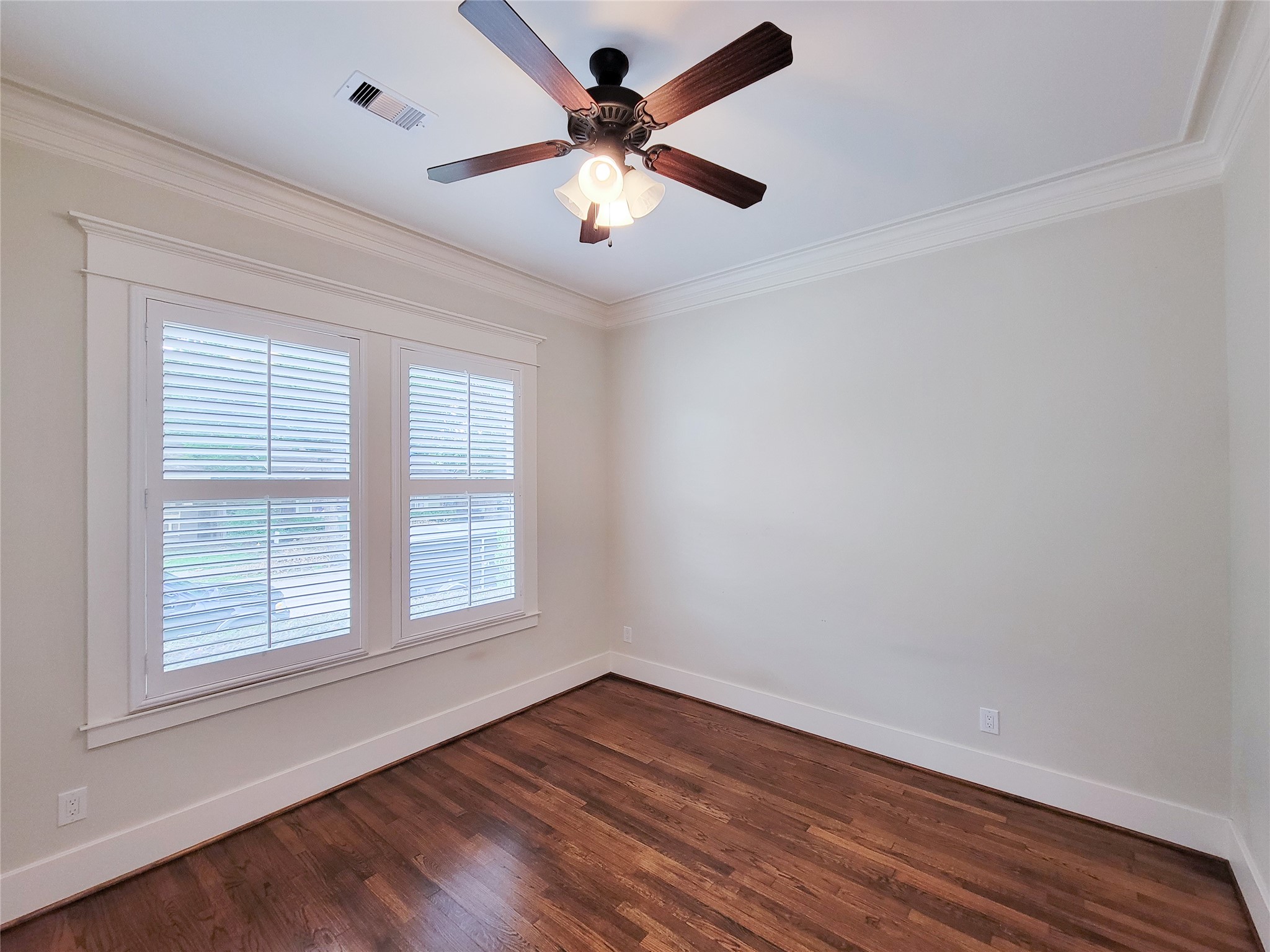 1140 West Cottage Street Houston, TX 77009 - Photo 22 of 37 an empty room with wooden floor chandelier fan and windows