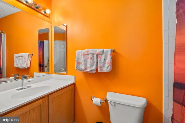 a bedroom with a bed and a dresser with wooden floor