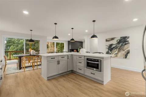 a kitchen with stainless steel appliances a stove a sink and white cabinets with wooden floor