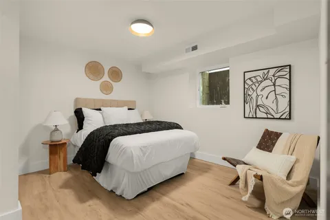 a bedroom with a bed and painting on the wall