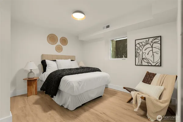 a bedroom with a bed and painting on the wall